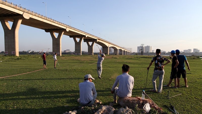 Không có tiền thuê sân bãi, tận dụng bãi cỏ xanh mướt nằm ở bờ bắc Sông Hồng, ngay dưới chân cầu Vĩnh Tuy, những nam thanh niên hành nghề caddy thường rủ nhau chơi golf những lúc rảnh rỗi.